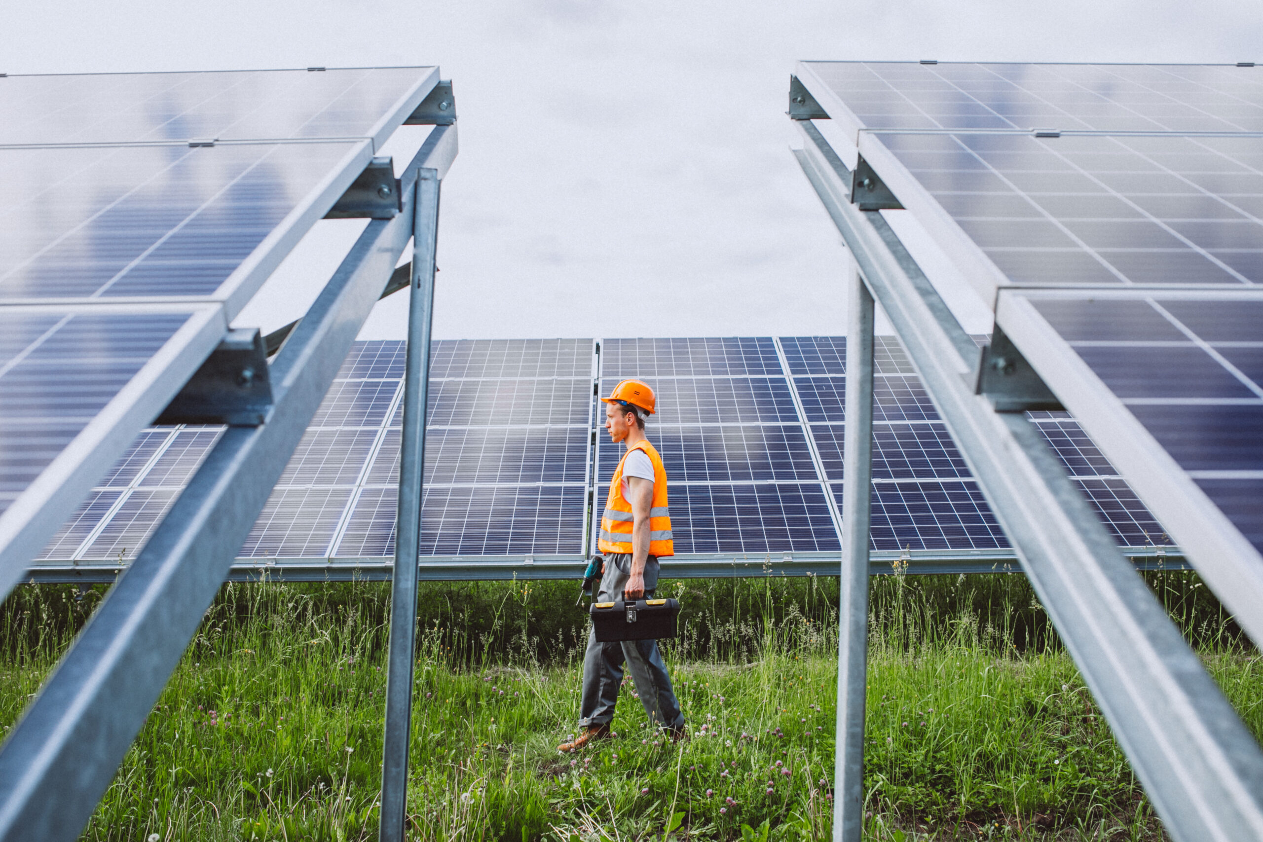 Man worker in the firld by the solar panels